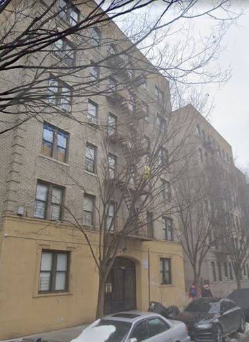 Bronx apartment for rent - a large brick building with cars parked in front of it