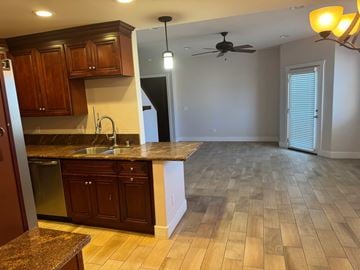 San Diego apartment for rent - A kitchen with wooden cabinets and a marble countertop.