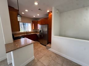 San Diego apartment for rent - A kitchen with a refrigerator, sink, and cabinets.