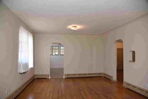Trinidad house for rent - an empty living room with white walls and wood floors