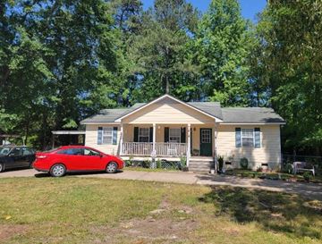 Fayetteville house for rent - A red car is parked in front of a yellow house.
