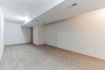 Louisville house for rent - the living room and dining room of an apartment with white walls and carpet
