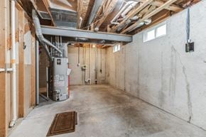 Louisville house for rent - the inside of a building with concrete walls and a water heater