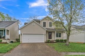 Louisville house for rent - a tan house with a white garage door on a driveway