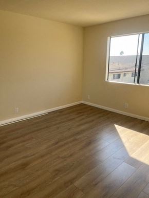 Hawthorne apartment for rent - an empty living room with wooden floors and a window