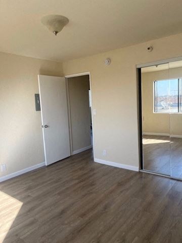 Hawthorne apartment for rent - an empty living room with a mirror and a door