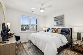 Atlanta apartment for rent - A bedroom with a large bed and a window overlooking a cityscape.