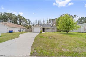 Jacksonville house for rent - A house with a driveway and a tree in front of it.