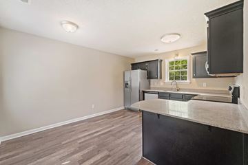 Jacksonville house for rent - A kitchen with a black counter and a refrigerator.