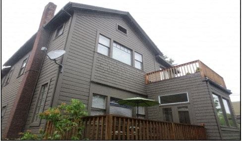 Portland apartment for rent - a gray house with a deck and an umbrella