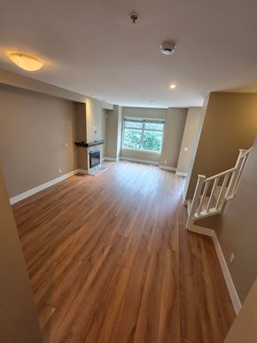 New Westminster apartment for rent - A room with wooden floors and a staircase.