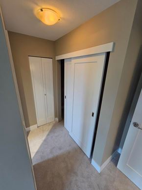 New Westminster apartment for rent - A hallway with a white door and a white cabinet.