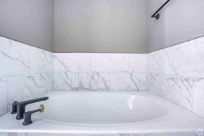 Columbus apartment for rent - A white bathroom with a marble tile wall and a white bathtub.