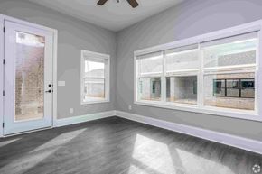 Columbus apartment for rent - A room with a white door, grey walls, and a window with a view of a brick building.