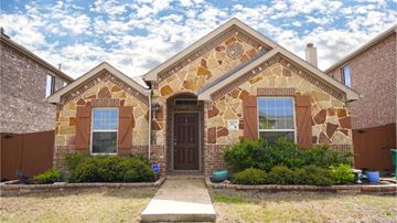 Heartland house for rent - a brick house with a brown door and a cloudy sky