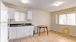 Vancouver house for rent - a kitchen with white cabinets and a sink and a table