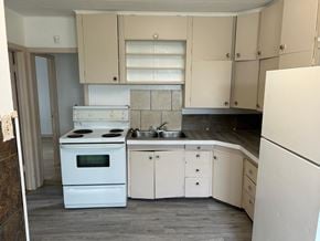 Prince Albert house for rent - an empty kitchen with white appliances and white cabinets