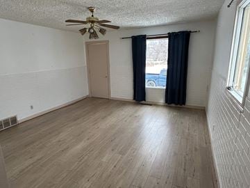 Prince Albert house for rent - a living room with a ceiling fan and a window with a curtain