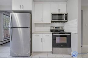 Edmonton apartment for rent - A modern kitchen with a stainless steel refrigerator, microwave, and oven.