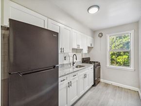Baltimore apartment for rent - a kitchen with white cabinets and a stainless steel refrigerator
