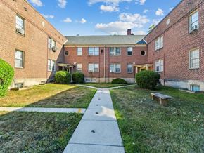 Baltimore apartment for rent - an exterior view of an apartment building with a sidewalk and grass