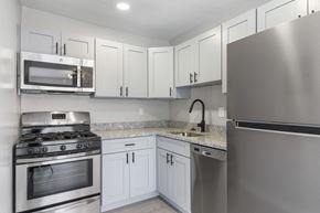 District Heights apartment for rent - A modern kitchen with stainless steel appliances and white cabinets.