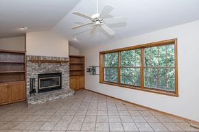 Rochester house for rent - A living room with a fireplace and a ceiling fan.