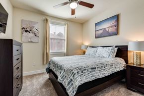 Dallas house for rent - a bedroom with a bed and a ceiling fan