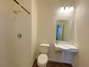 Merced house for rent - A white toilet sits next to a white sink in a small bathroom.