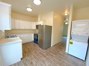 Merced house for rent - A kitchen with a refrigerator, oven, and microwave.
