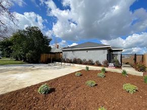 Merced house for rent - a house with a driveway and a yard with dirt and plants