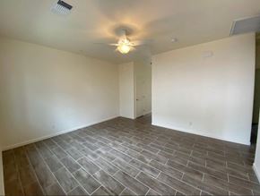 Merced house for rent - a empty living room with tile flooring and a ceiling fan