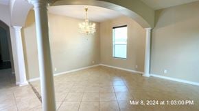 Clermont house for rent - an empty dining room with pillars and a chandelier