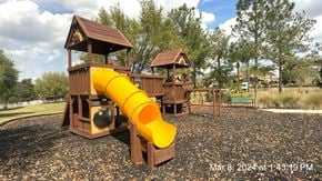 Clermont house for rent - a playground with a yellow slide in a park