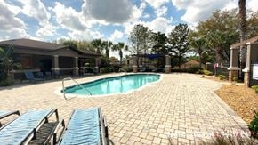 Clermont house for rent - a swimming pool in a backyard with chairs and a house