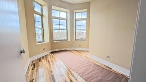 Chicago apartment for rent - an empty room with a rug on the floor and three windows