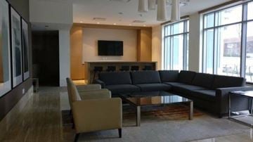 Surrey apartment for rent - A modern living room with a black couch and a television.