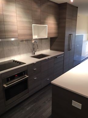Surrey apartment for rent - A modern kitchen with dark wood cabinets and stainless steel appliances.
