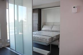Surrey apartment for rent - A bedroom with a bed, a window, and a white wall.
