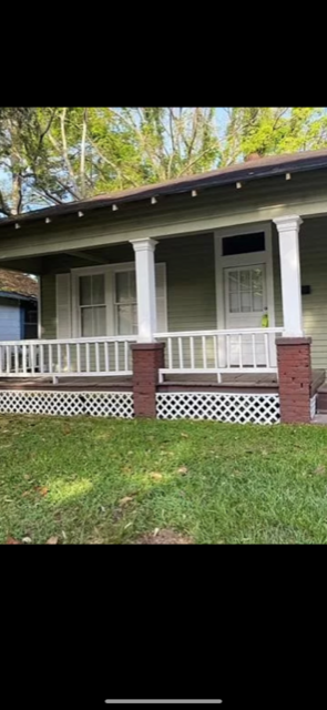 Mobile house for rent - a white house with a porch and a lawn