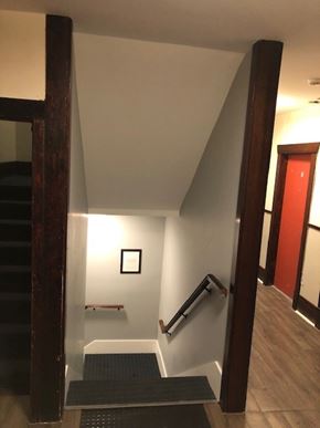 Vancouver apartment for rent - A hallway with a staircase and a red door.
