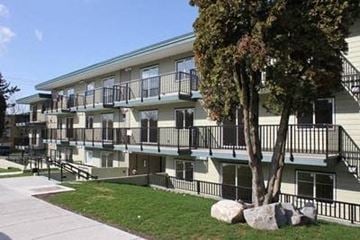 Vancouver apartment for rent - Apartment building with balconies and a tree in front.