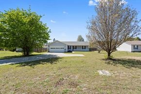 Richlands house for rent - A white house with a driveway and a leafless tree in front.