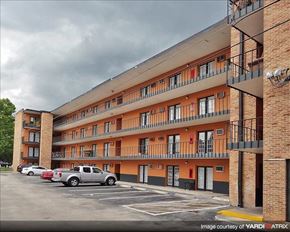 Gainesville apartment for rent - an apartment building with cars parked in a parking lot