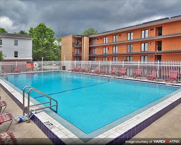 Gainesville apartment for rent - a large blue pool in front of an apartment building