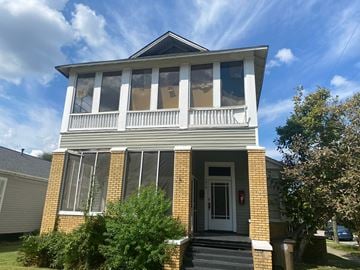 Mobile house for rent - the front of a brick house with a white porch