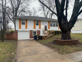 Kansas City house for rent - a white house with a large tree in front of it