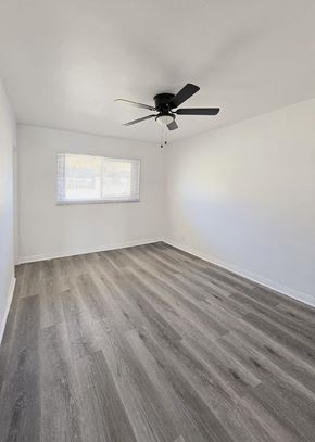 Anaheim apartment for rent - A room with a ceiling fan and a window with blinds.