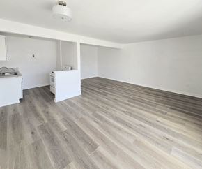 Anaheim apartment for rent - A room with a grey wood floor and white walls.