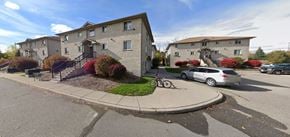 Kitchener apartment for rent - A street view of a residential area with a car parked on the side of the road.
